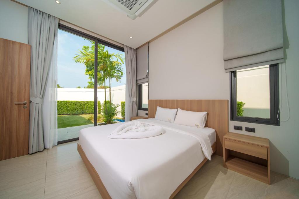 Villa bedroom with garden view through sliding glass doors