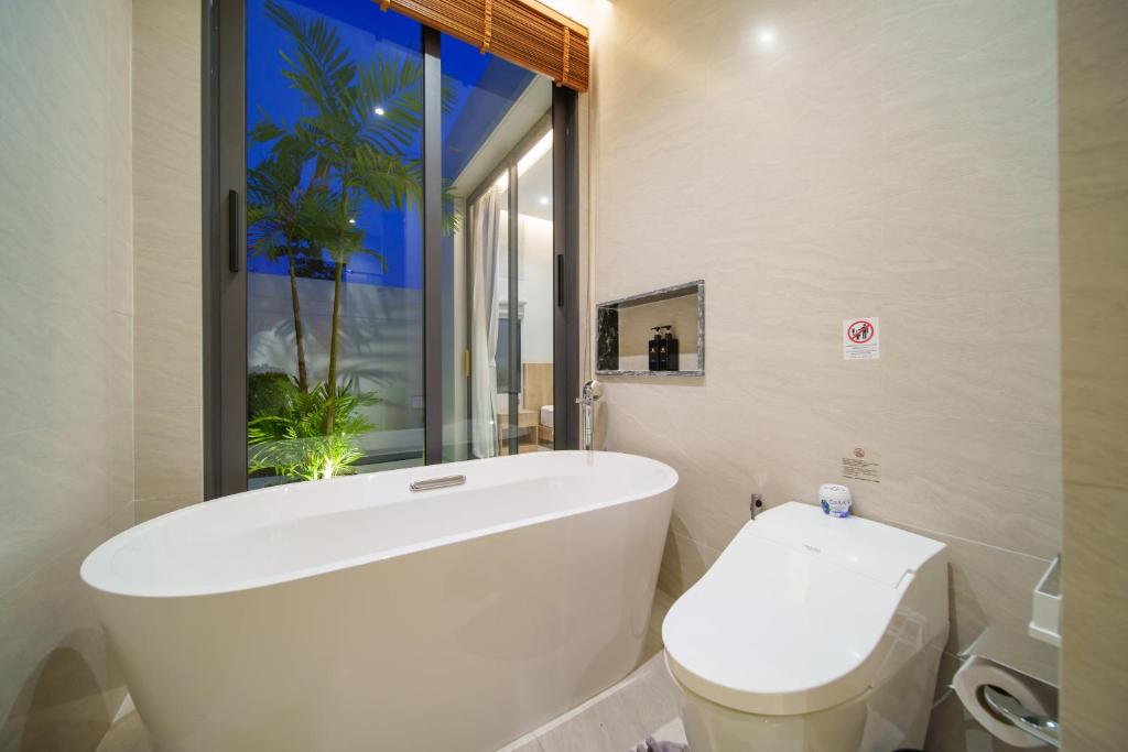 Villa bathroom with soaking tub and night garden view